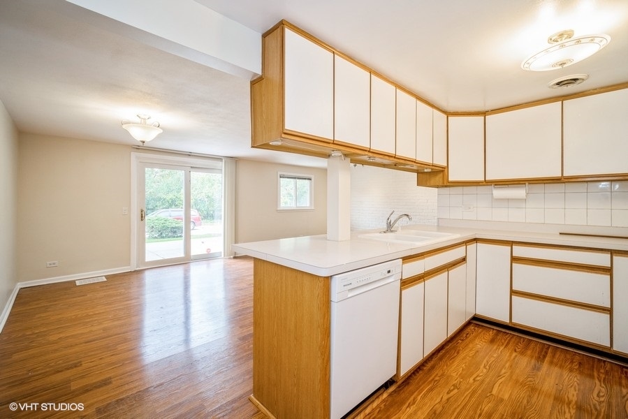 912 Chestnut Street Deerfield, IL 60015 - Photo 12 of 20 a kitchen with stainless steel appliances granite countertop a sink and cabinets with wooden floor