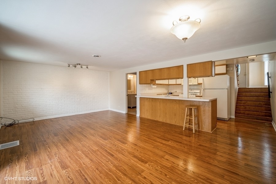 912 Chestnut Street Deerfield, IL 60015 - Photo 14 of 20 a view of a kitchen with kitchen island a sink wooden floor and a glass door