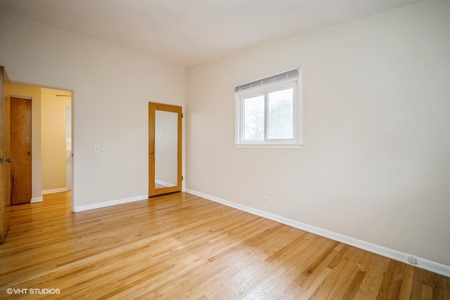 912 Chestnut Street Deerfield, IL 60015 - Photo 7 of 20 a view of an empty room with wooden floor and a window