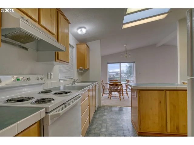 a kitchen with stainless steel appliances granite countertop a sink stove and cabinets