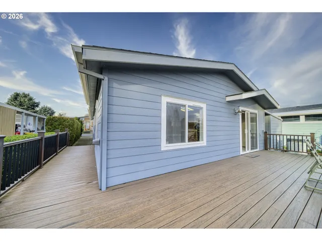a view of a roof deck with table and chairs a barbeque with wooden floor and fence