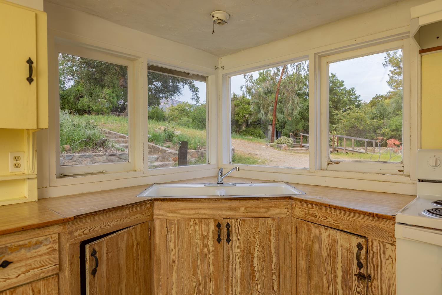 11954 Sulphur Mountain Road Ojai, CA 93023 - Photo 36 of 41 a kitchen with a window a sink and wooden cabinets