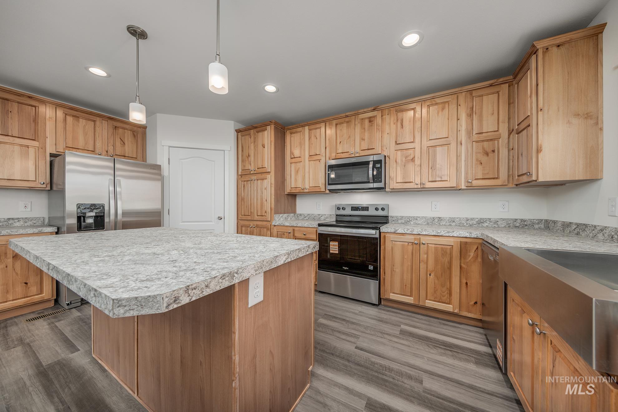 2750 Alden Road, Unit 8 Fruitland, ID 83619 - Photo 3 of 31 Kitchen featuring stainless steel appliances, a kitchen island, light countertops, decorative light fixtures, and dark wood-type flooring