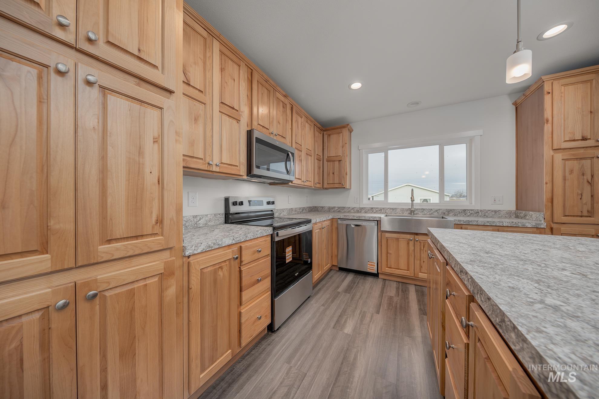 2750 Alden Road, Unit 8 Fruitland, ID 83619 - Photo 6 of 31 Kitchen featuring stainless steel appliances, light countertops, pendant lighting, dark wood-style flooring, and light wood finish cabinetry