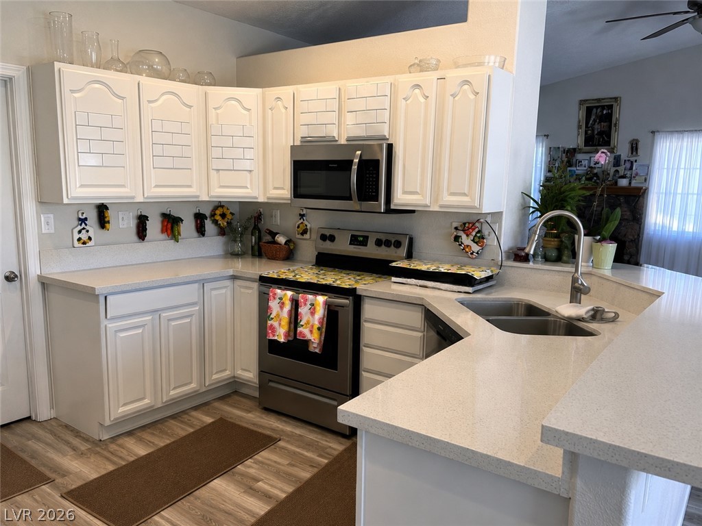 200 East Gamebird Road Pahrump, NV 89048 - Photo 6 of 23 A corner kitchen showcases sleek stainless steel appliances, abundant cabinet storage, and light countertops.