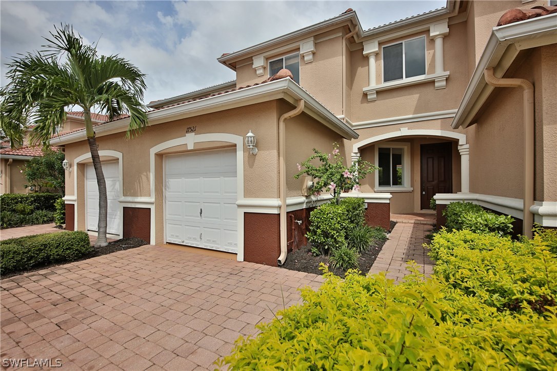 17521 Cherry Ridge Lane Fort Myers, FL 33967 - Photo 1 of 23 a front view of a house with a yard and potted plants
