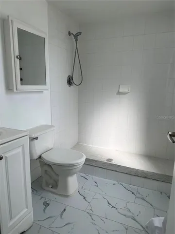 a bathroom with a toilet sink and shower