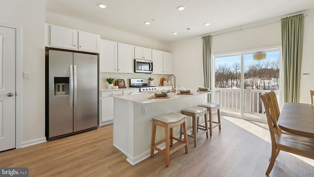 586 Swamp Creek Road Boyertown, PA 19512 - Photo 10 of 26 a kitchen with stainless steel appliances granite countertop a refrigerator a stove top oven a sink with island and chairs