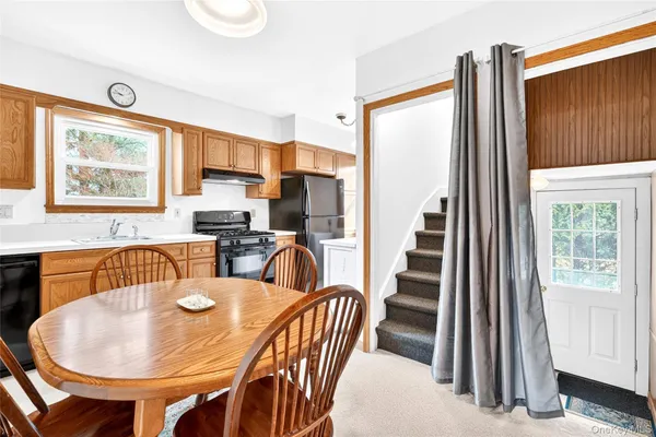 a view of a dining room with furniture and a kitchen