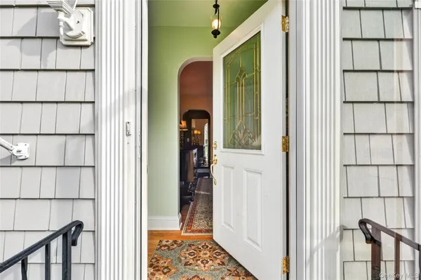 a view of a hallway with wooden floor and windows