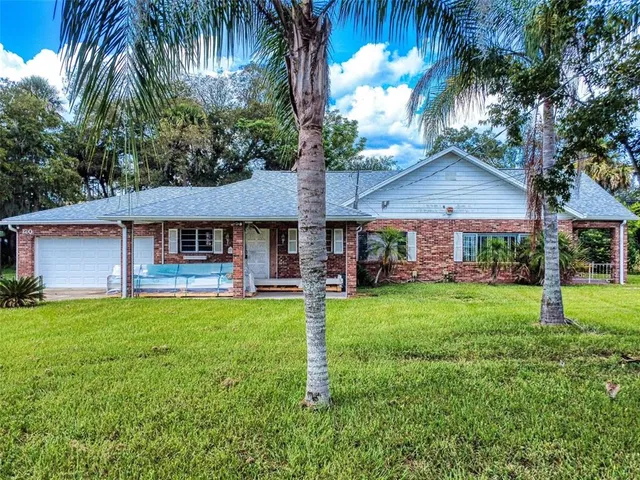 a view of a house with a yard and sitting area