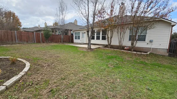a view of a house with backyard and a tree