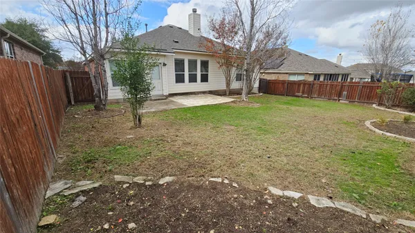 a view of a yard in front of a house with a large tree