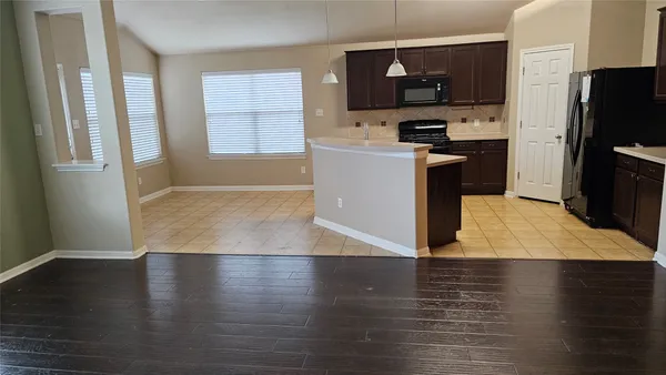 a kitchen with stainless steel appliances granite countertop a refrigerator a sink a stove top oven a counter space and cabinets