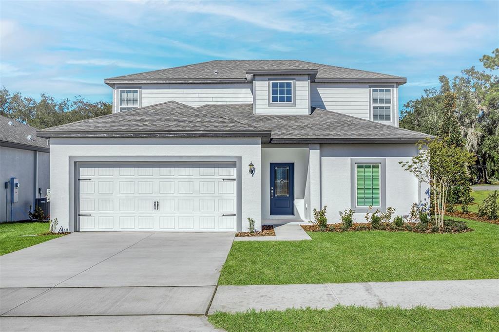 a front view of a house with a yard and garage