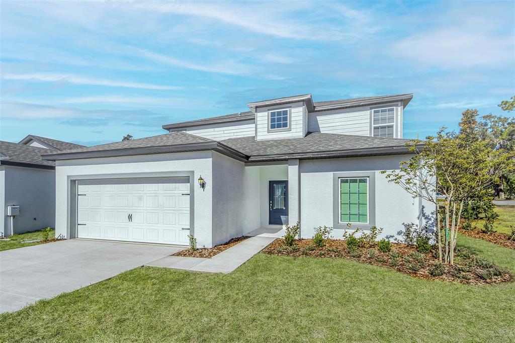 13347 Tula Loop Astatula, FL 34705 - Photo 2 of 21 a front view of a house with a yard and garage
