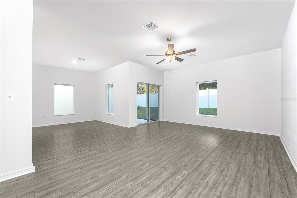 13347 Tula Loop Astatula, FL 34705 - Photo 3 of 21 an empty room with wooden floor and windows