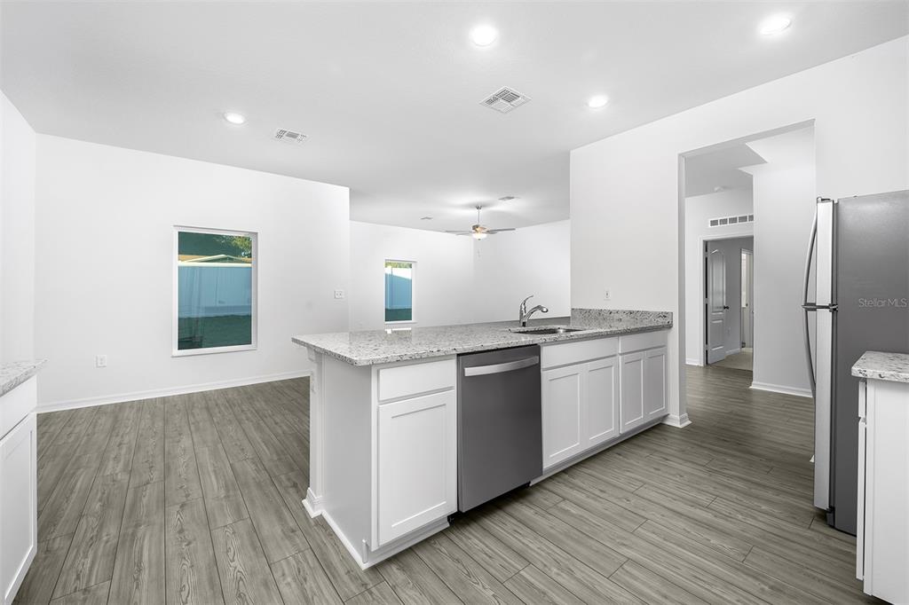 13347 Tula Loop Astatula, FL 34705 - Photo 6 of 21 a kitchen with granite countertop a refrigerator and a sink