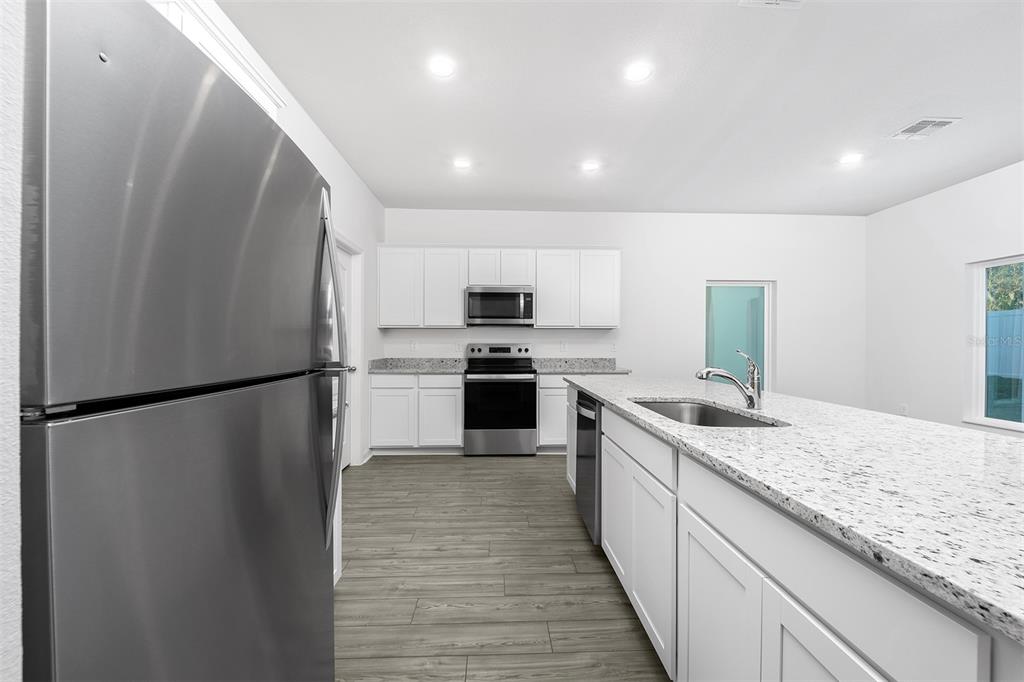 13347 Tula Loop Astatula, FL 34705 - Photo 7 of 21 a kitchen with a refrigerator a sink and a stove