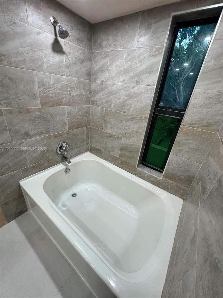 9440 Southwest 8th Street, Unit 402 Boca Raton, FL 33428 - Photo 14 of 45 a white bath tub sitting in a bathroom
