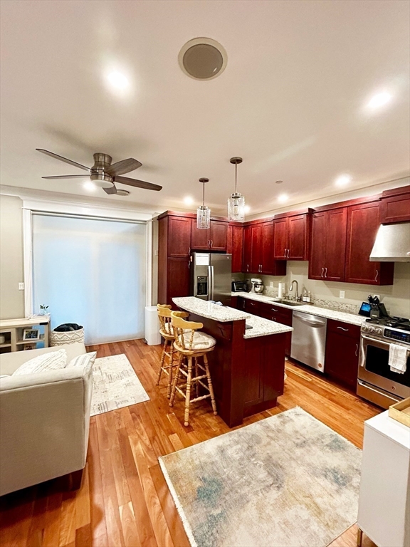 a kitchen with stainless steel appliances kitchen island granite countertop a sink dishwasher stove and cabinets