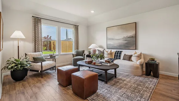a living room with furniture potted plant and a large window