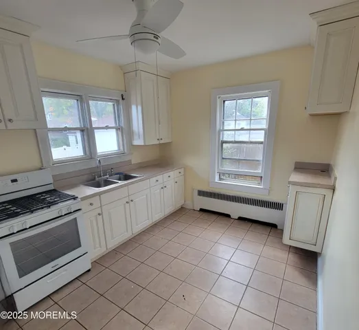 a kitchen with a stove a sink and a window