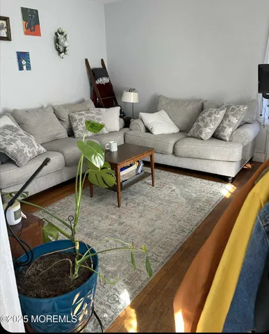a living room with furniture a rug and a flat screen tv