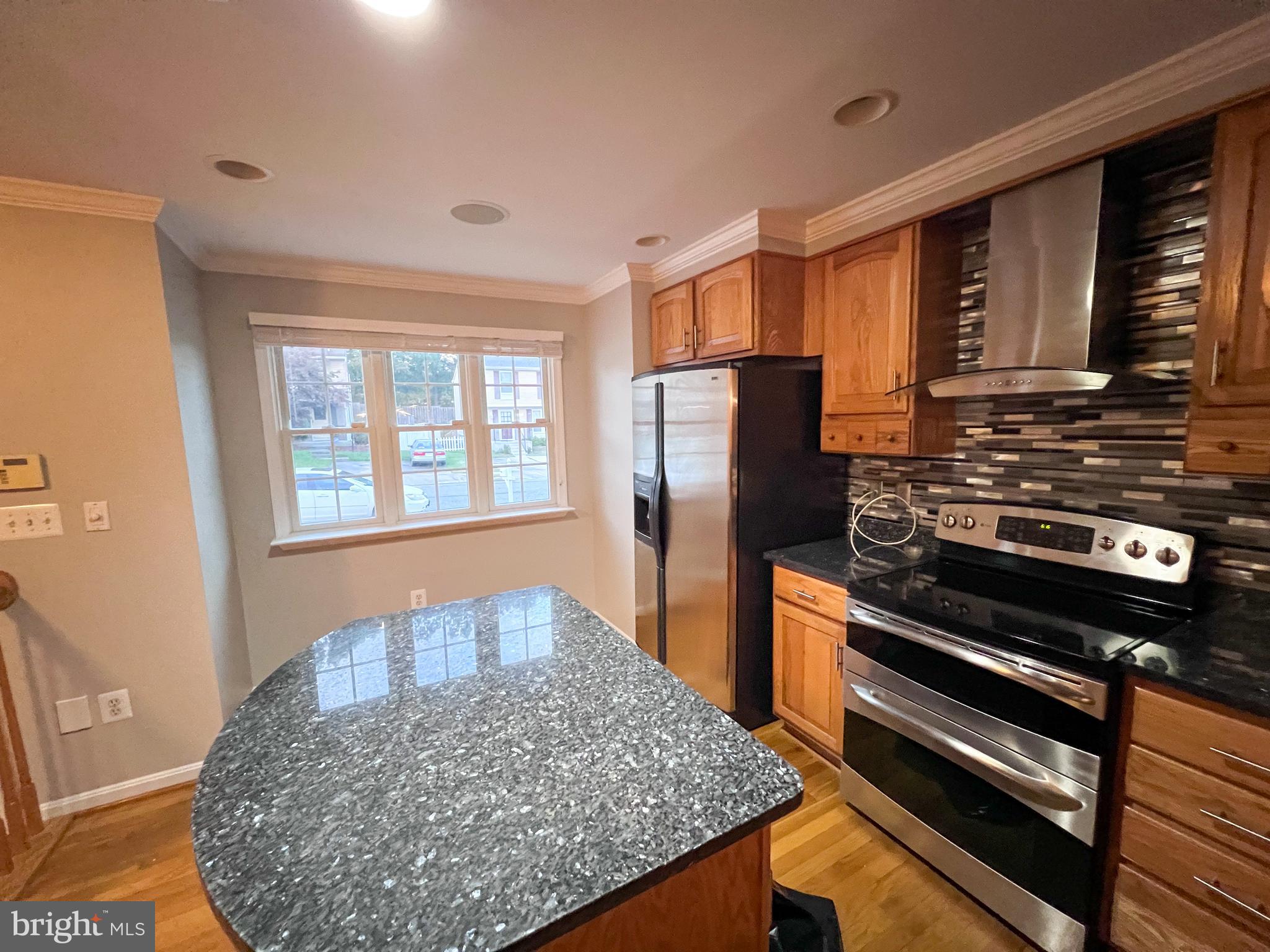 8514 Rhuddlan Road Nottingham, MD 21236 - Photo 18 of 34 a kitchen with stainless steel appliances kitchen island granite countertop a stove refrigerator and microwave