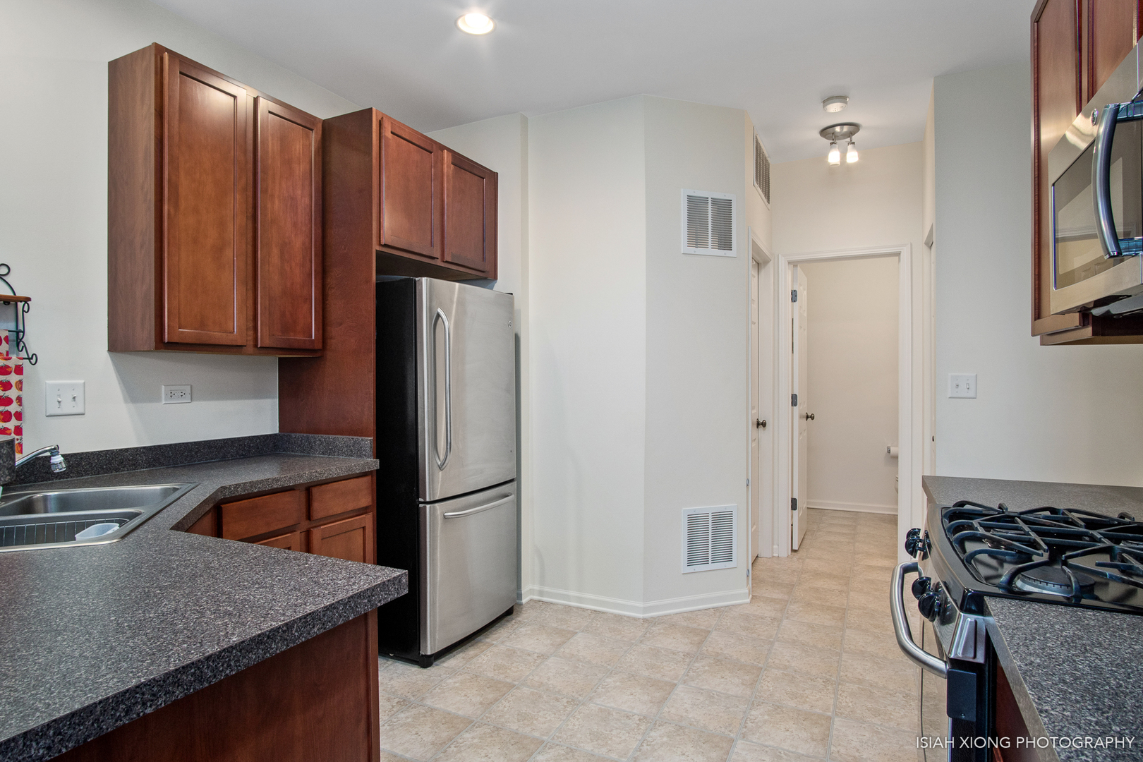 445 Dancer Lane, Unit 405 Oswego, IL 60543 - Photo 5 of 32 a kitchen with stainless steel appliances granite countertop a refrigerator and a sink