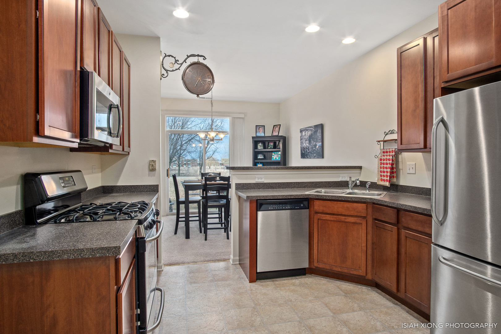 445 Dancer Lane, Unit 405 Oswego, IL 60543 - Photo 6 of 32 a kitchen with stainless steel appliances granite countertop a stove refrigerator sink and cabinets