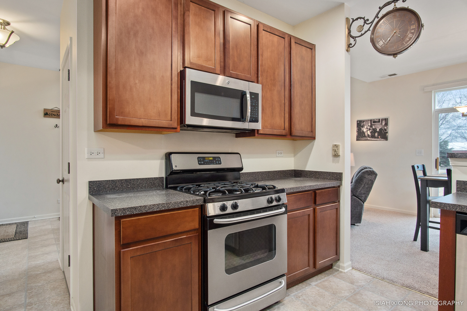 445 Dancer Lane, Unit 405 Oswego, IL 60543 - Photo 7 of 32 a kitchen with stainless steel appliances granite countertop a stove a microwave and wooden cabinets
