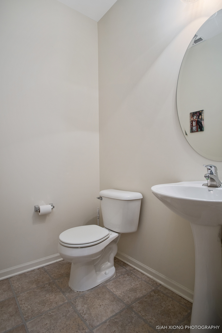 445 Dancer Lane, Unit 405 Oswego, IL 60543 - Photo 9 of 32 a white toilet sitting next to a bathroom sink