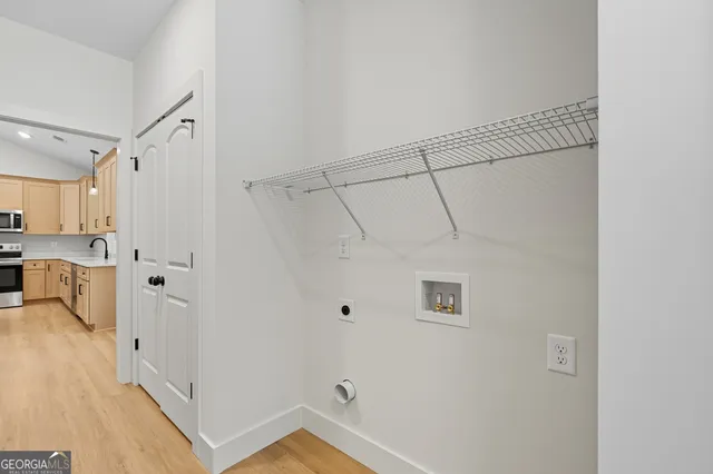 a view of a kitchen with white cabinets and wooden floor