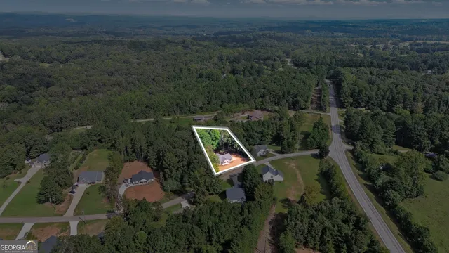 an aerial view of a house with swimming pool and garden