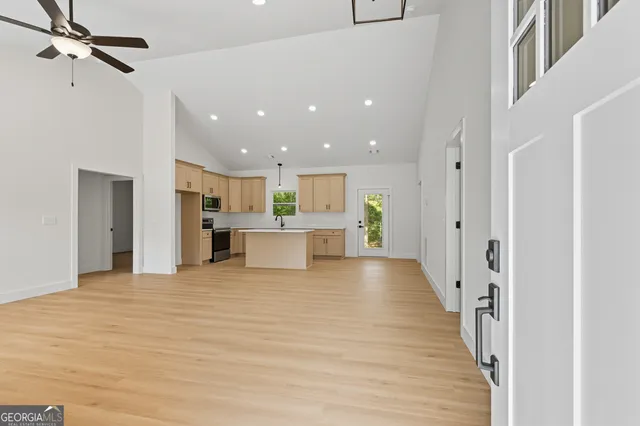a view of a kitchen with kitchen island a sink stainless steel appliances and cabinets