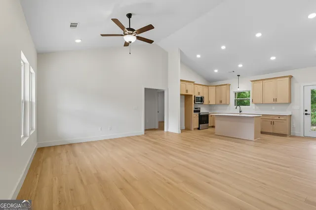 a view of kitchen with granite countertop cabinets and refrigerator