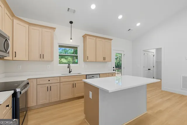 a kitchen with a sink cabinets and window