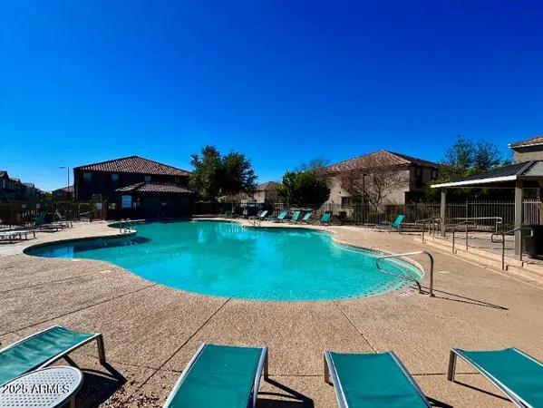 a view of a swimming pool with lawn chairs under an umbrella