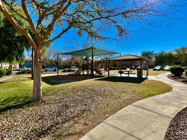 a view of a yard with table and chairs under an umbrella