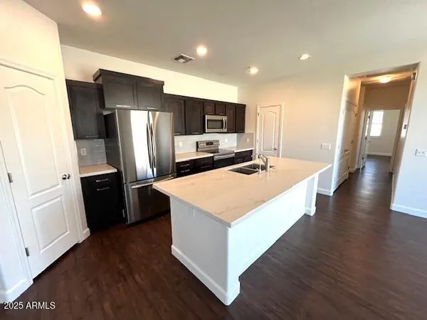 a large kitchen with stainless steel appliances a refrigerator and a stove top oven