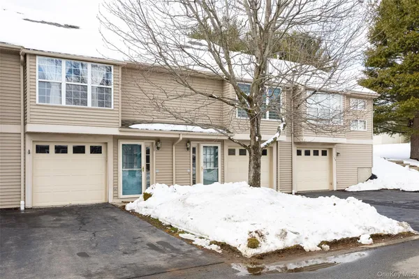 a view of a white house with a large tree