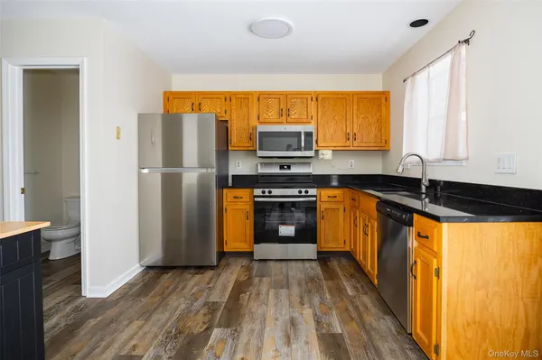 a kitchen with stainless steel appliances a stove top oven a sink and a refrigerator