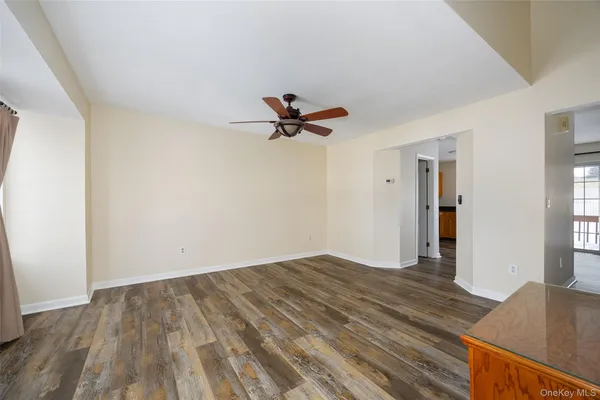 a view of a room with wooden floor and a ceiling fan