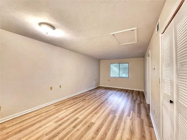 an empty room with wooden floor and windows