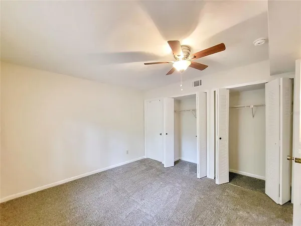 an empty room with a window and a ceiling fan