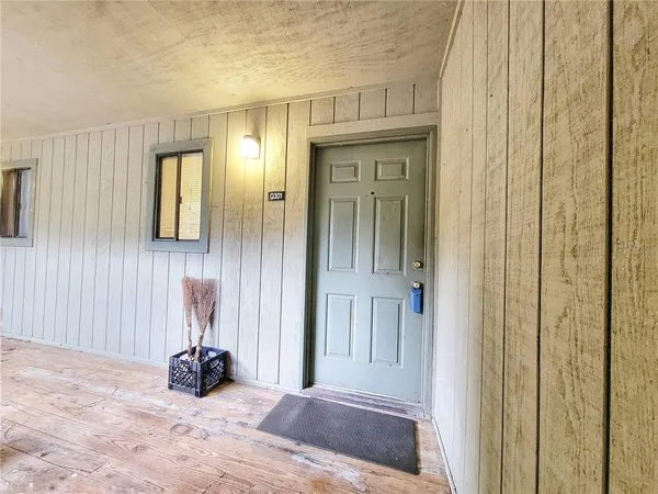 a view of a hallway with a livingroom and a window