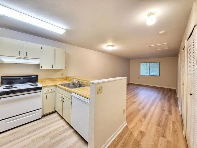 a room with a white wooden cabinets and white appliances