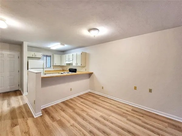a room with a white wooden cabinets and white appliances