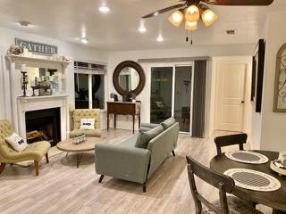 a living room with furniture a fireplace and a large window
